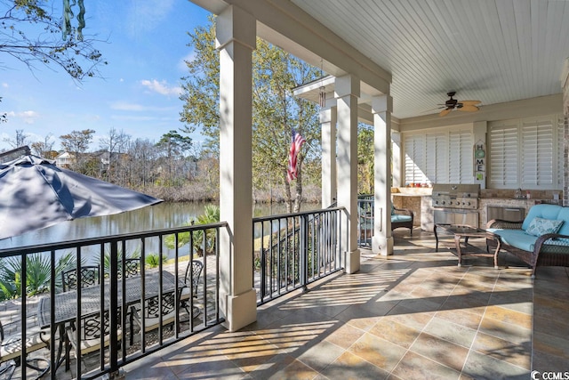 view of patio / terrace with area for grilling, ceiling fan, and a water view