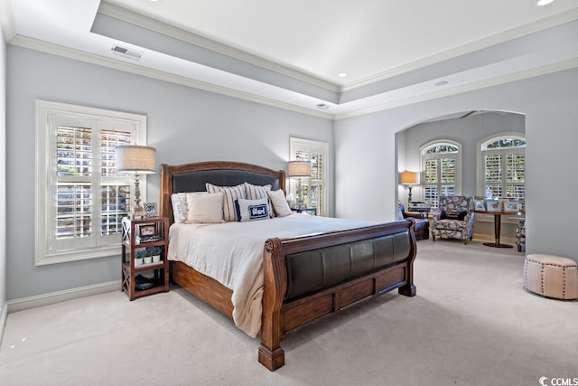 carpeted bedroom featuring a tray ceiling and crown molding