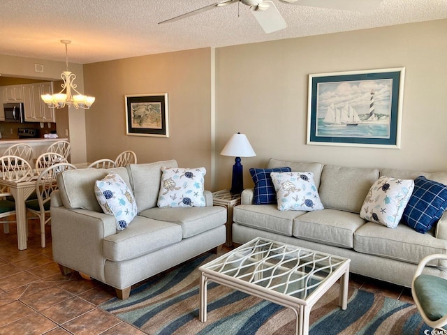 tiled living room featuring ceiling fan with notable chandelier and a textured ceiling