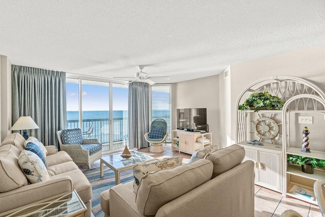 living room featuring a textured ceiling, a wall of windows, and ceiling fan