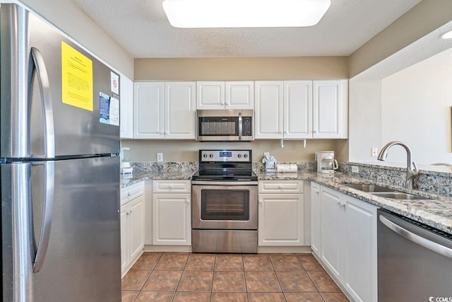 kitchen featuring stainless steel appliances, white cabinetry, and sink