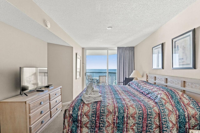 carpeted bedroom with a textured ceiling and access to outside