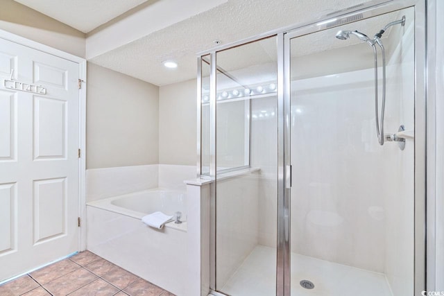 bathroom featuring plus walk in shower, a textured ceiling, and tile patterned flooring