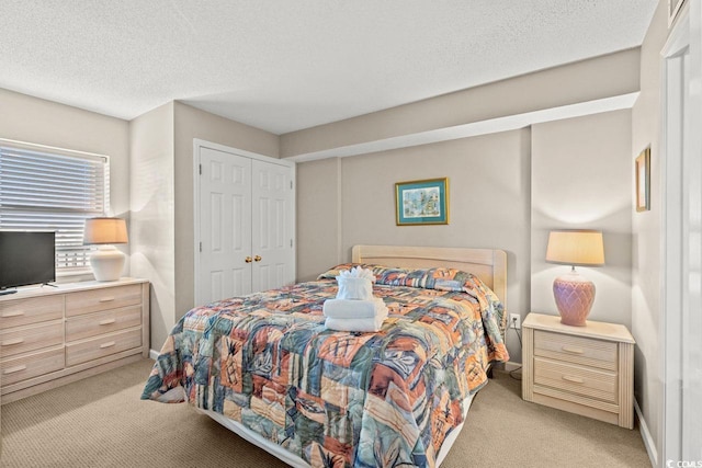 carpeted bedroom with a closet and a textured ceiling