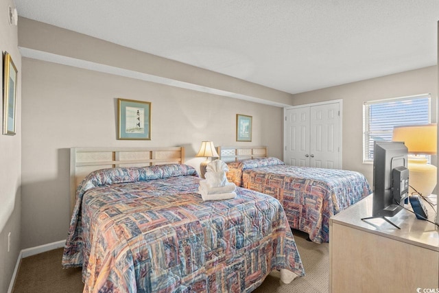 bedroom with carpet, a textured ceiling, and a closet