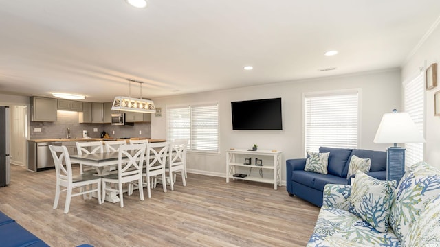 interior space featuring light hardwood / wood-style floors, crown molding, and sink