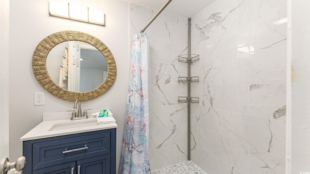 bathroom with tiled shower and vanity