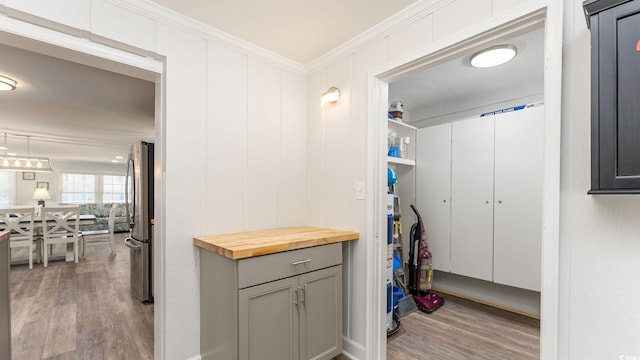 interior space with light hardwood / wood-style floors and ornamental molding