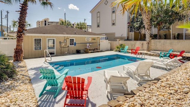 pool with a patio area and fence