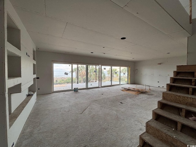 unfurnished living room featuring carpet and a wealth of natural light