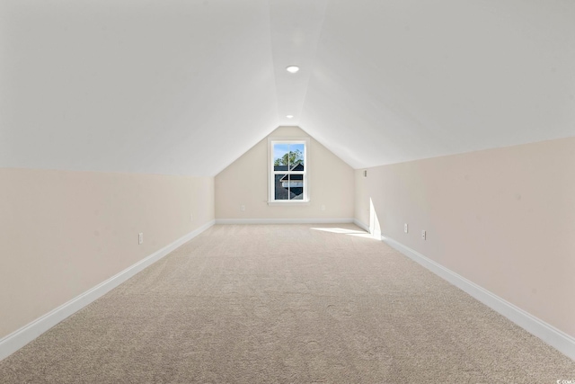 additional living space featuring carpet, vaulted ceiling, and baseboards