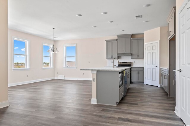 kitchen with a center island with sink, gray cabinetry, dark hardwood / wood-style flooring, a notable chandelier, and pendant lighting