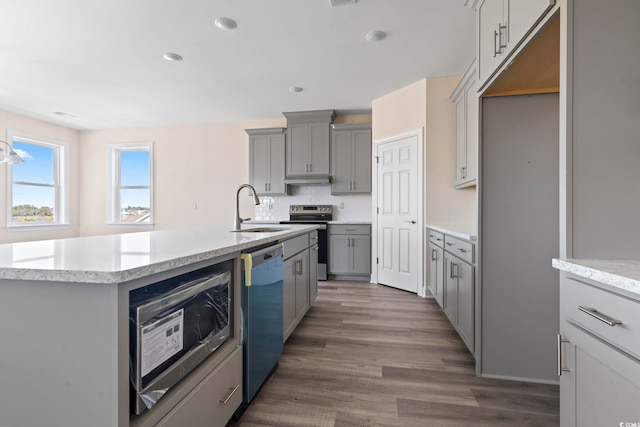 kitchen with appliances with stainless steel finishes, sink, gray cabinetry, an island with sink, and decorative backsplash