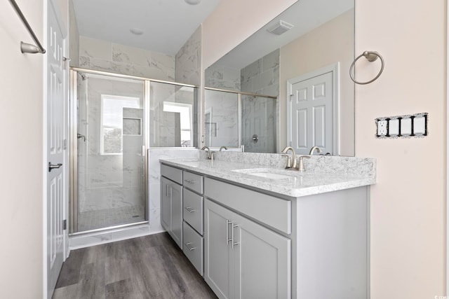 bathroom featuring hardwood / wood-style flooring, vanity, and an enclosed shower