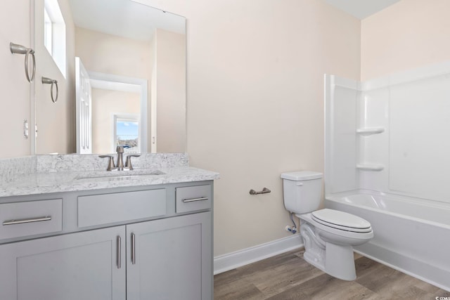 full bathroom with hardwood / wood-style flooring, shower / washtub combination, vanity, and toilet