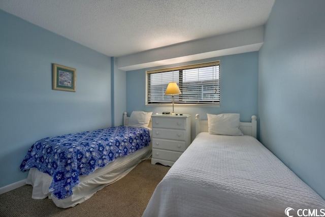 bedroom featuring a textured ceiling and light colored carpet