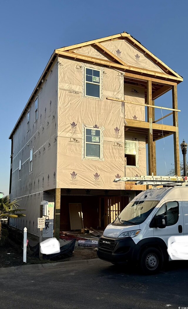 view of front of home with a garage, a balcony, and a front yard