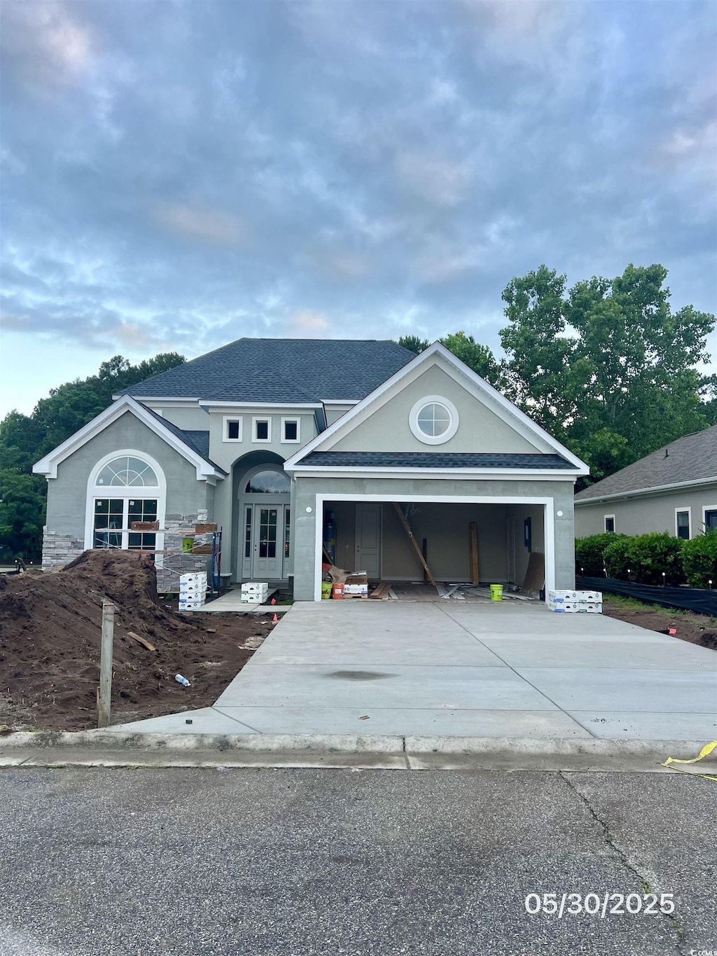 5508 Via Verde Dr, North Myrtle Beach, SC 29582 - view of front of house featuring concrete driveway, an attached garage, stucco siding, and a shingled roof