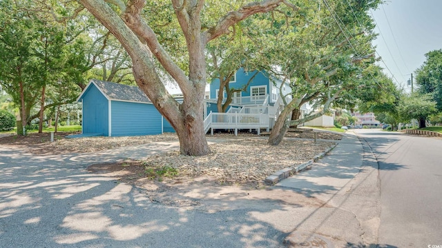 view of front of property featuring an outbuilding and a shed