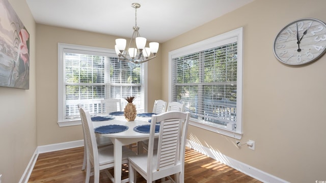 dining room with baseboards, a chandelier, and wood finished floors