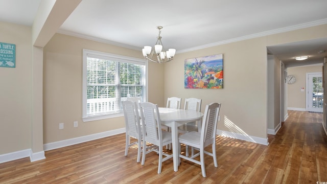 dining space with baseboards, a chandelier, wood finished floors, and ornamental molding