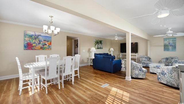 dining room featuring light wood-style flooring, baseboards, ornamental molding, and ceiling fan with notable chandelier