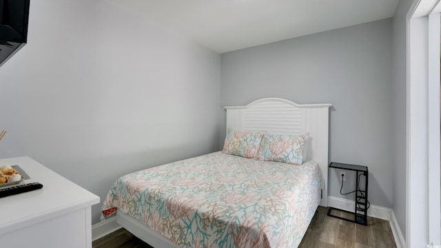 bedroom with baseboards and wood finished floors