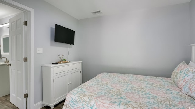 bedroom with dark wood finished floors and visible vents