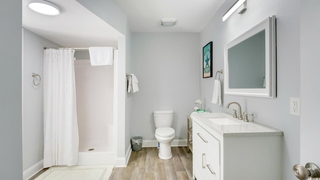 full bath with vanity, a shower stall, toilet, and wood finished floors