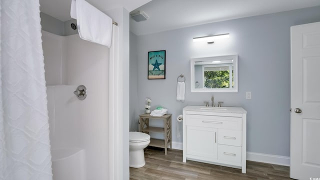 full bathroom featuring a shower with shower curtain, toilet, vanity, wood finished floors, and baseboards