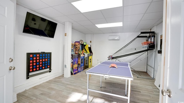 game room with wood finish floors and a paneled ceiling