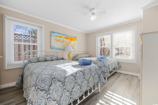 bedroom with ornamental molding, a textured ceiling, ceiling fan, and light wood-type flooring