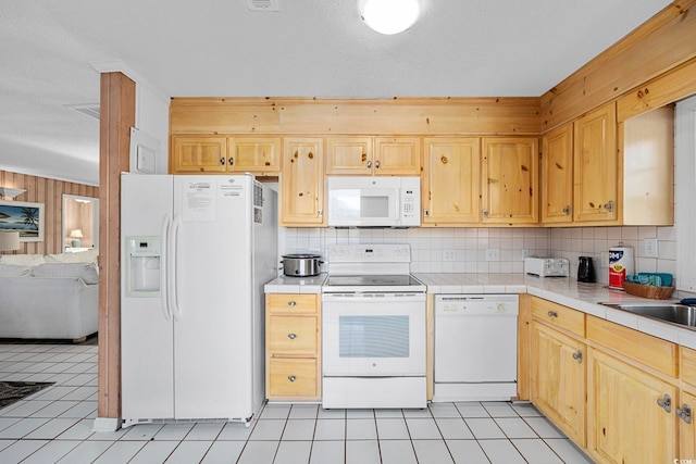 kitchen with white appliances, backsplash, and light tile floors