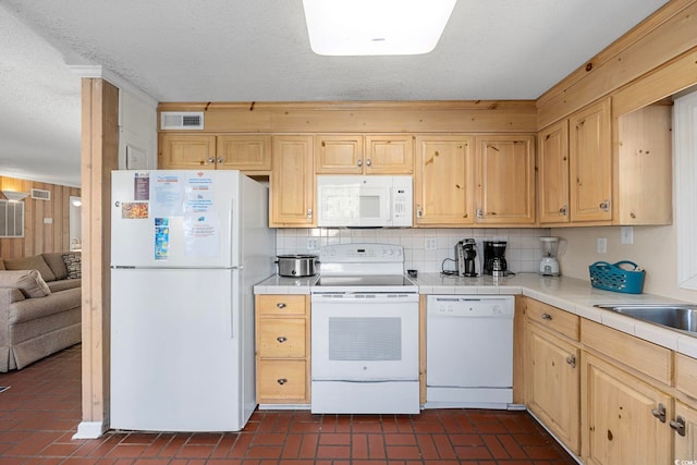 kitchen featuring backsplash, light brown cabinets, tile counters, and white appliances