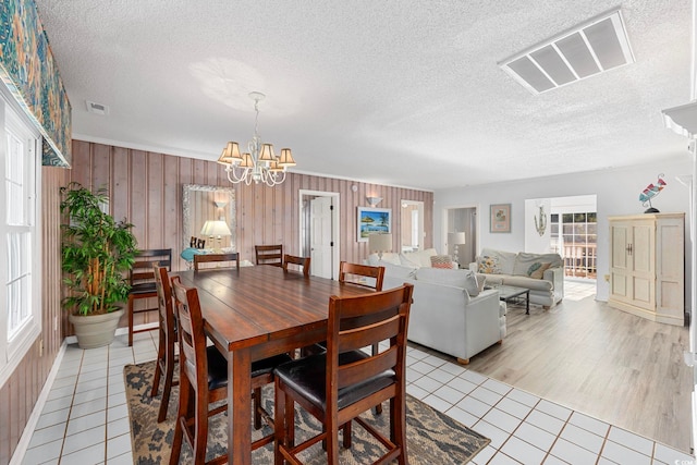 dining room with plenty of natural light, a chandelier, and light tile floors