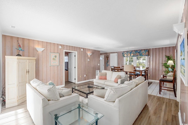 living room with light hardwood / wood-style flooring and wood walls