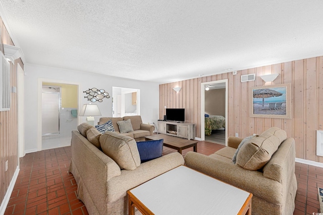 living room with wood walls and a textured ceiling