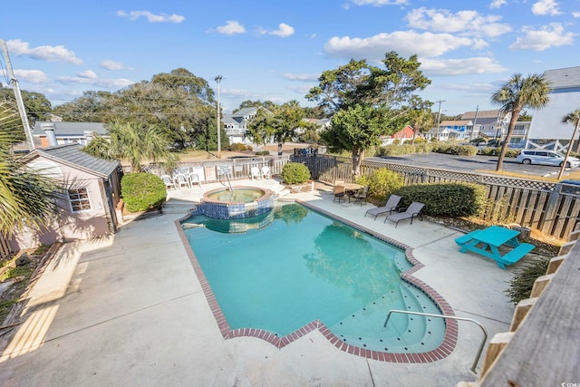 view of pool featuring a patio and an in ground hot tub