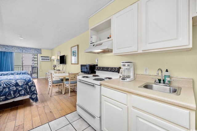 kitchen with electric range, white cabinetry, a textured ceiling, light hardwood / wood-style floors, and sink