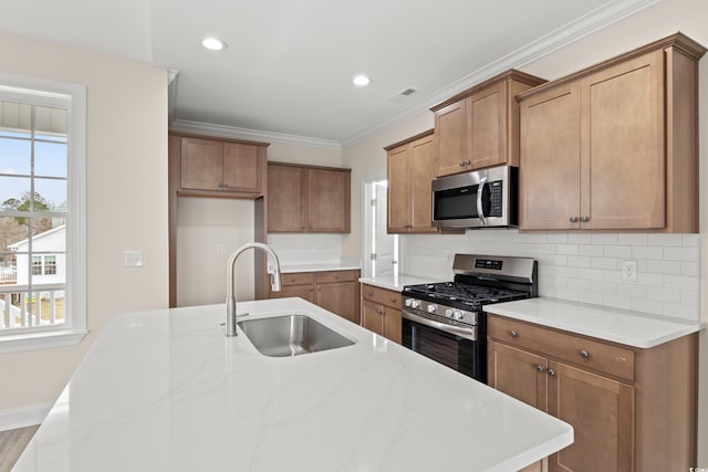 kitchen featuring a sink, ornamental molding, appliances with stainless steel finishes, backsplash, and brown cabinets