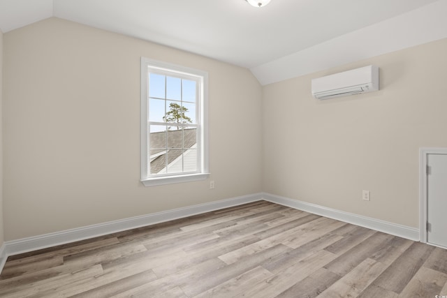 additional living space with lofted ceiling, an AC wall unit, wood finished floors, and baseboards