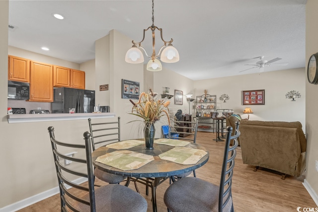 dining space featuring ceiling fan with notable chandelier, baseboards, light wood-style flooring, and recessed lighting