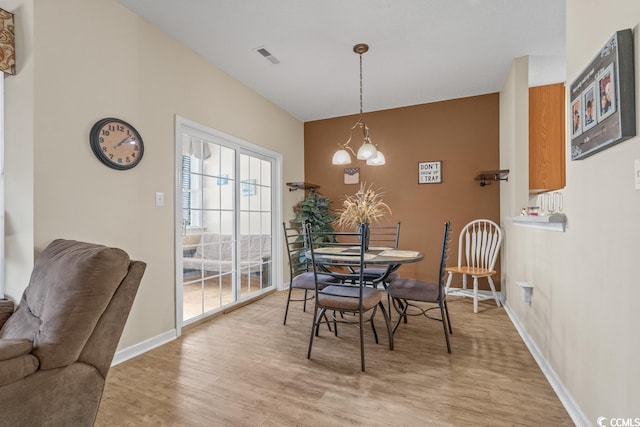 dining room featuring light wood-style floors, visible vents, and baseboards