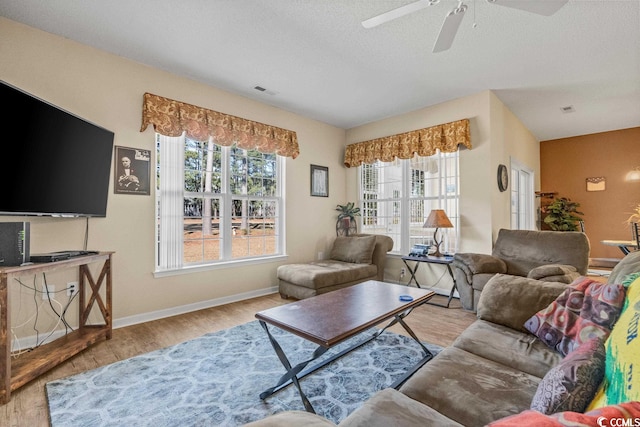 living room featuring a healthy amount of sunlight, baseboards, and wood finished floors