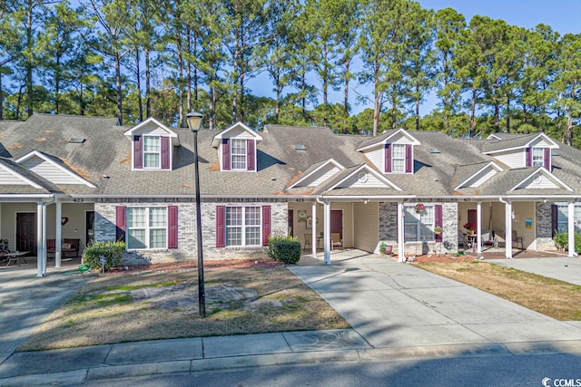 multi unit property featuring brick siding, driveway, and roof with shingles