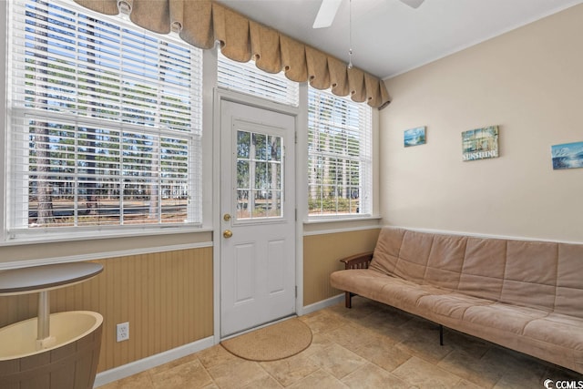 doorway with a ceiling fan and baseboards