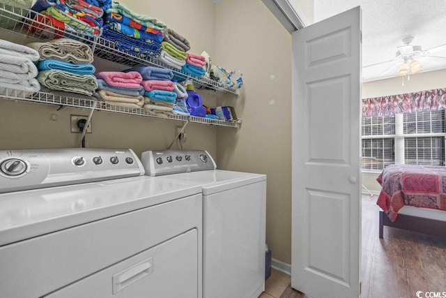 laundry area with ceiling fan, laundry area, baseboards, light wood-type flooring, and independent washer and dryer