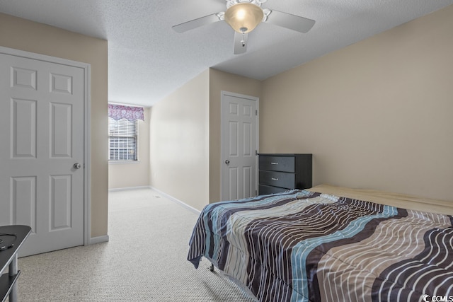 carpeted bedroom featuring ceiling fan, baseboards, and a textured ceiling