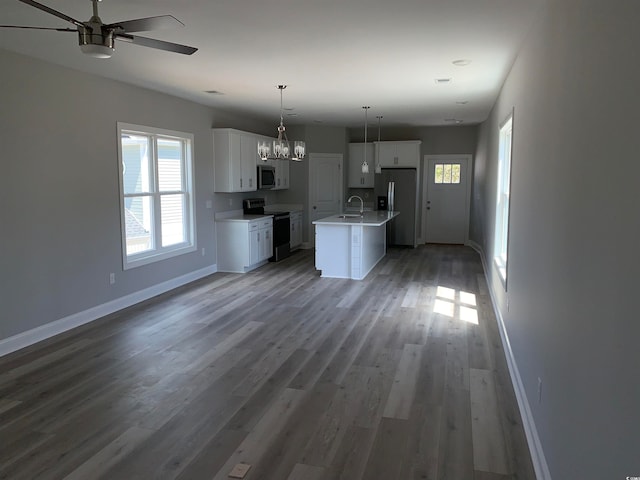 kitchen featuring an island with sink, light hardwood / wood-style floors, stainless steel appliances, decorative light fixtures, and ceiling fan with notable chandelier