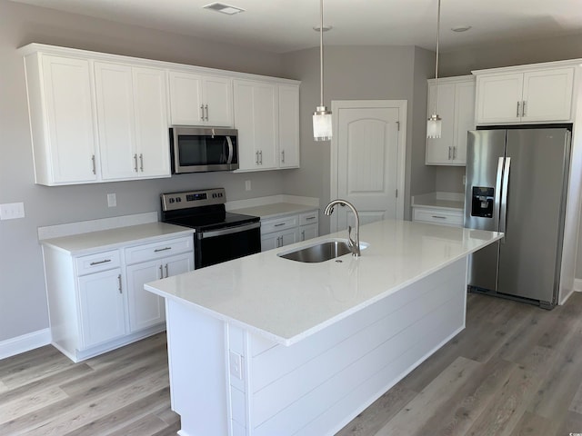 kitchen with white cabinets, a center island with sink, and stainless steel appliances